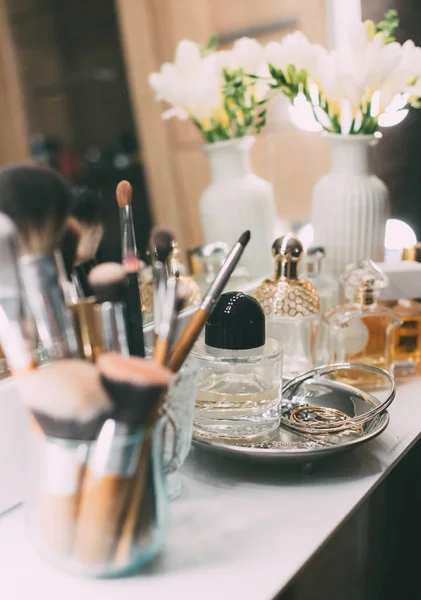 Profumeria e cosmetici su una toletta con uno specchio — Foto Stock