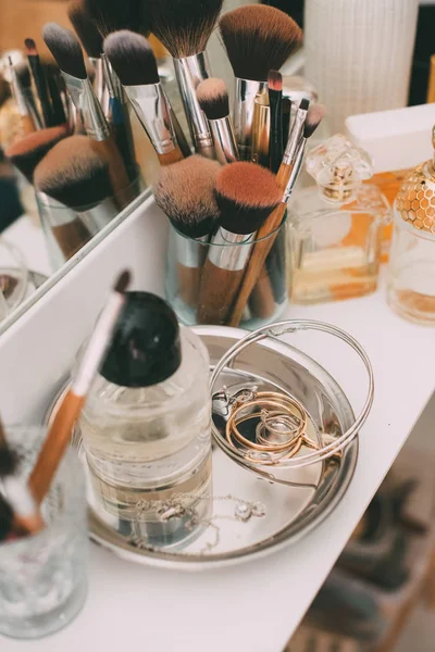 Perfumaria e cosméticos em uma mesa de vestir com um espelho — Fotografia de Stock