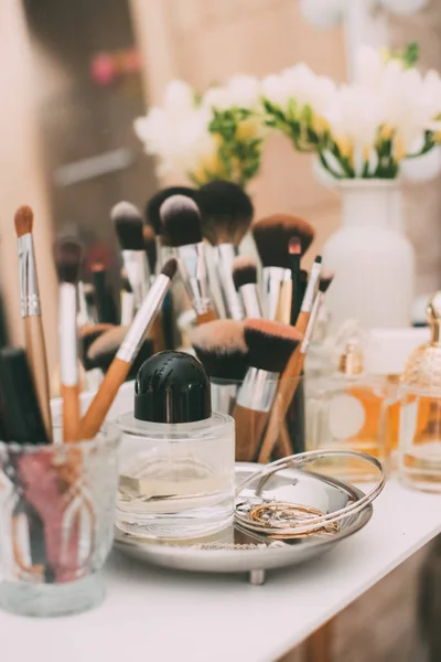 Perfumaria e cosméticos em uma mesa de vestir com um espelho — Fotografia de Stock