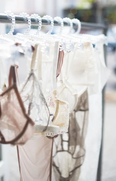 Elegant lacy lingerie on hanger in backlight — Stock Photo, Image