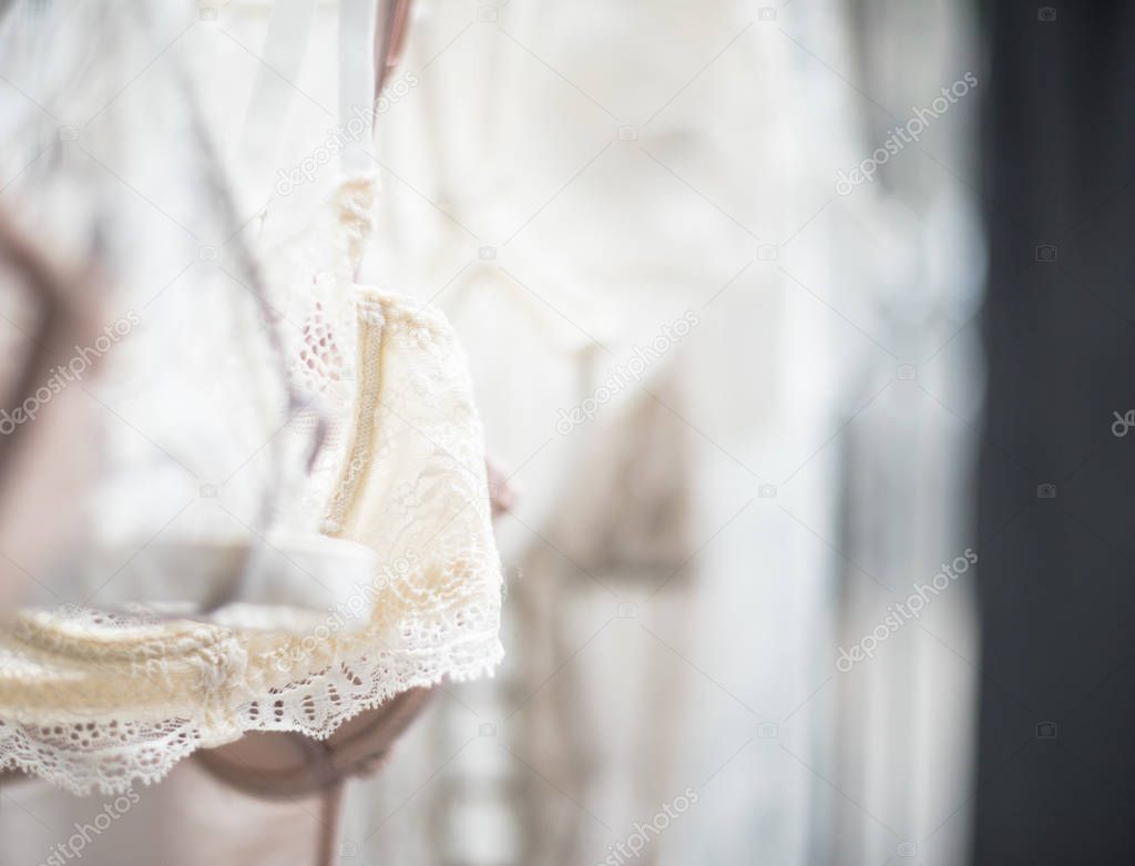 Elegant lacy lingerie on hanger in backlight, lace clothes detal