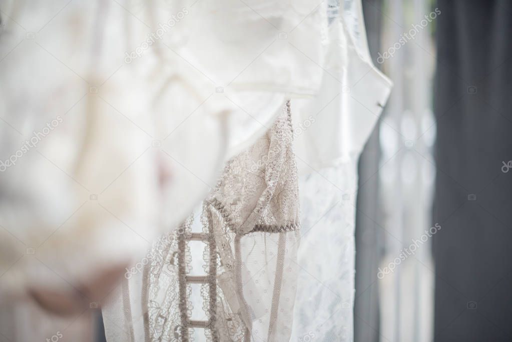 Elegant lacy lingerie on hanger in backlight, lace clothes detal