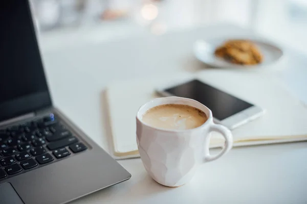 Σύγχρονη λευκό γραφείο, σχεδιαστής χειροποίητη κεραμική κούπα καφέ, smartpho — Φωτογραφία Αρχείου