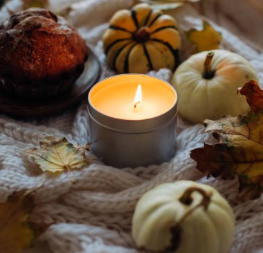 Yanan mum kavanozu, sonbahar yaprakları ve küçük dekoratif pumpki