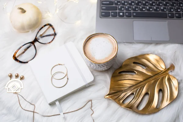 Lady bloggers white work space with gold details, laptop and cof