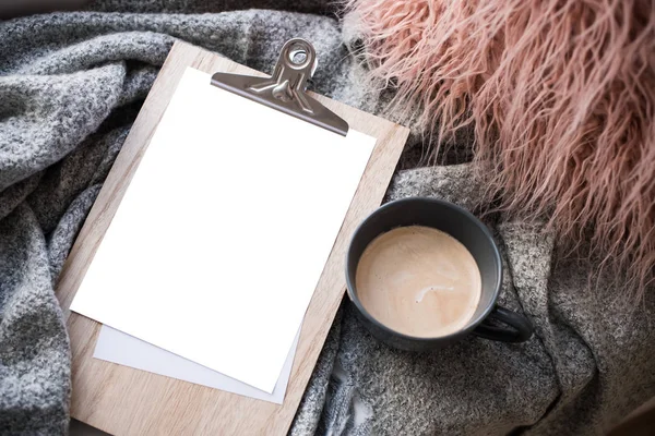 Cozy home arrangement with coffee cup and blank clipboard mockup