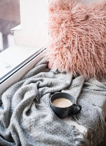Copa de café, manta de punto y almohada mullida en el acogedor alféizar de la ventana — Foto de Stock