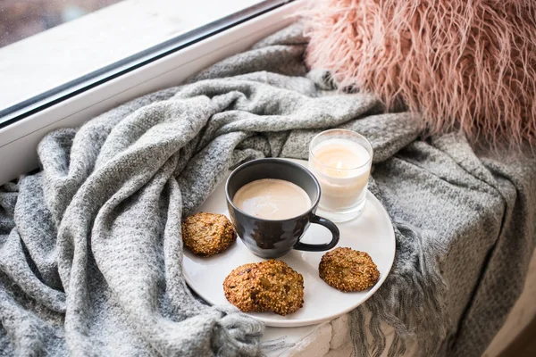 Scandinavische stijl ontbijt, kopje koffie en koekjes op gezellige vensterbank met warme deken en kussen — Stockfoto