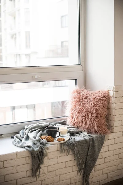 Colazione in stile scandinavo, tazza di caffè e biscotti sul davanzale della finestra accogliente con coperta calda e cuscino — Foto Stock