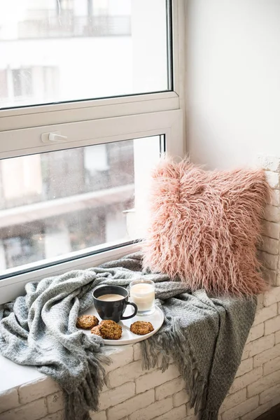 Petit déjeuner de style scandinave, tasse de café et biscuits sur le rebord de la fenêtre confortable avec couverture chaude et oreiller — Photo