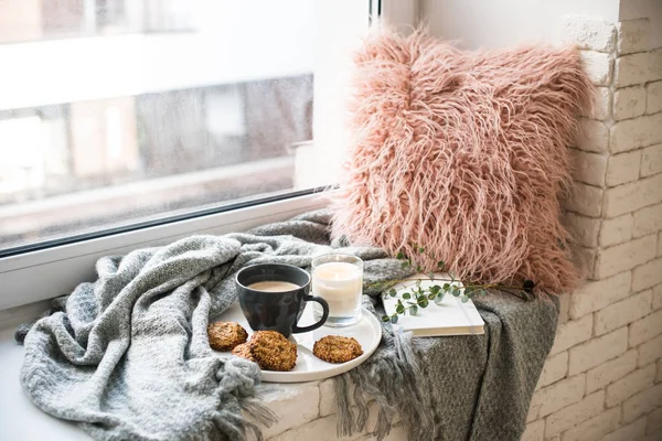 Petit déjeuner de style scandinave, tasse de café et biscuits sur le rebord de la fenêtre confortable avec couverture chaude et oreiller — Photo