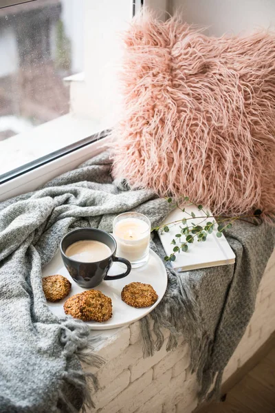 Скандинавский завтрак, чашка кофе и печенье на уютном подоконнике с теплым одеялом и подушкой — стоковое фото