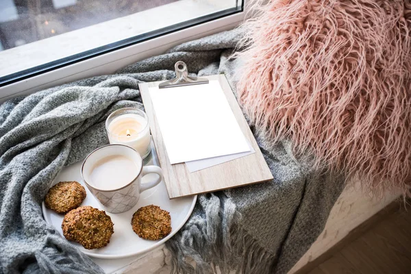 Cozy home arrangement with coffee cup and blank clipboard mockup