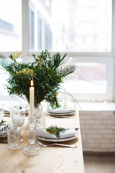 Beau cadre de table de printemps avec des feuilles vertes et des branches de mimosa, décoration de dîner de table blanche lumineuse — Photo
