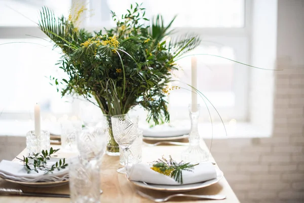 Hermosa mesa de primavera con hojas verdes y ramas mimosas, decoración de mesa blanca brillante —  Fotos de Stock