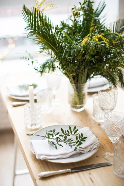 Hermosa mesa de primavera con hojas verdes y ramas mimosas, decoración de mesa blanca brillante — Foto de Stock