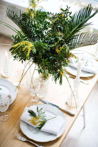 Hermosa mesa de primavera con hojas verdes y ramas mimosas, decoración de mesa blanca brillante —  Fotos de Stock