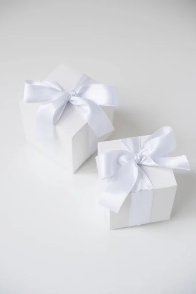 Wo white square boxes with silk ribbon on white background — Stock Photo, Image