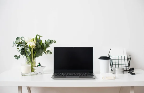 Hipster bloggare arbetsplats, laptop och blommor på vit bordsskiva — Stockfoto