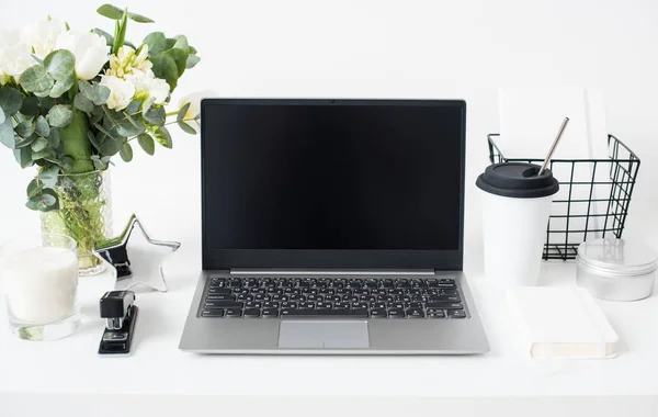 Hipster bloggare arbetsplats, laptop och blommor på vit bordsskiva — Stockfoto