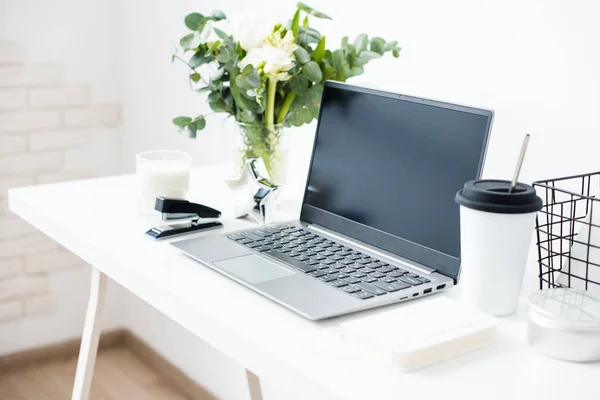 Hipster bloggers werkplek, laptop en bloemen op wit tafelblad — Stockfoto