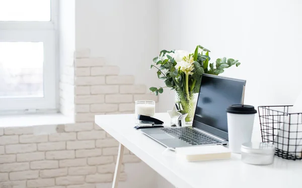 Hipster bloggers werkplek, laptop en bloemen op wit tafelblad — Stockfoto