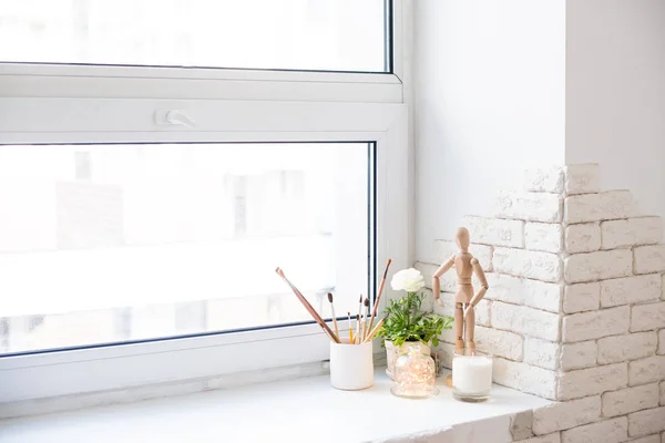Zeitgemäße Wohnkultur mit Ranunkeln und Kerzen auf der Fensterbank — Stockfoto