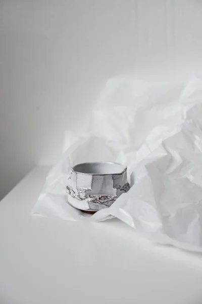 Handgefertigte Keramikvase auf verbeultem weißem Papier — Stockfoto