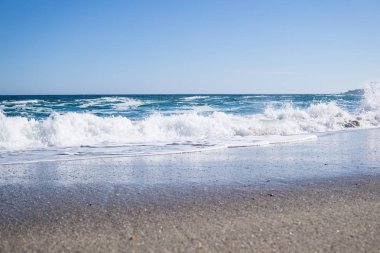 Sahilde, parlak mavi su dalgalar deniz