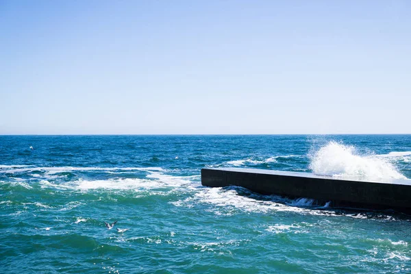 Zee golven op het strand, helder blauw water — Stockfoto