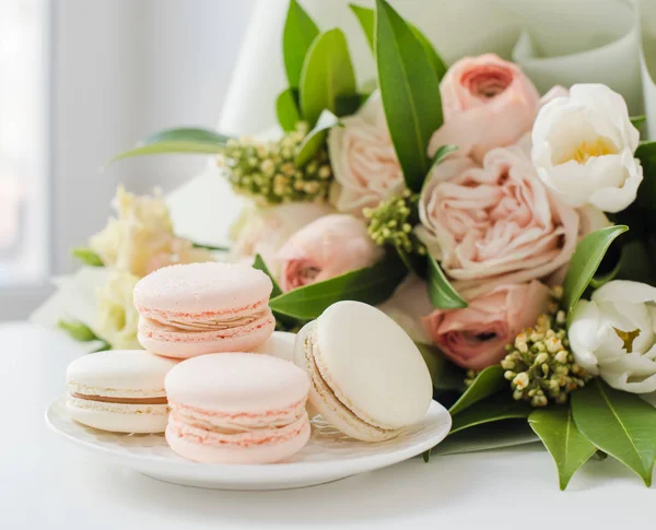 Elegant sweet macarons and pastel colored beige flowers — Stock Photo, Image