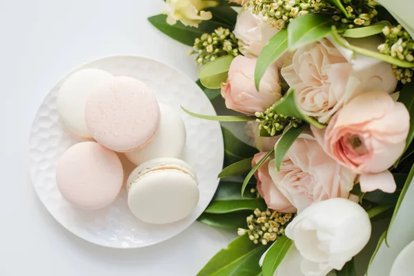 Eleganckie słodkie makarony i pastelowe kolorowe kwiaty beżowy — Zdjęcie stockowe