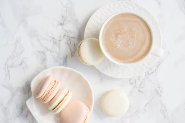 Elegant sweet dessert macarons and cup of coffee on white marble table — Stock Photo, Image