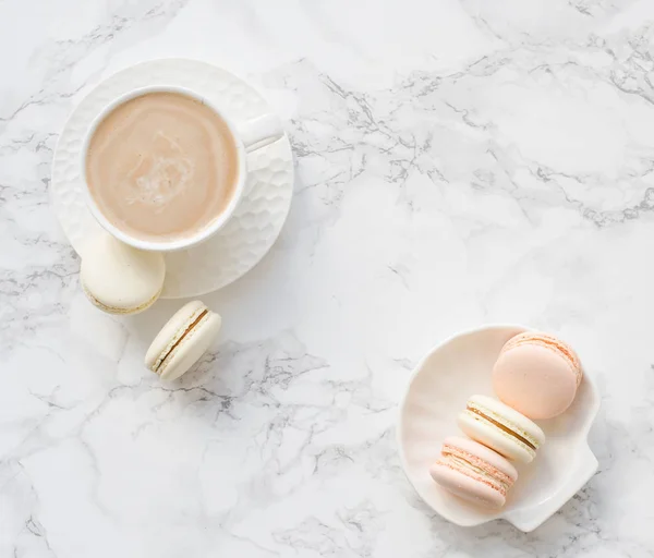 Елегантний солодкий десерт макарони і чашка кави на білому мармуровому столі — стокове фото