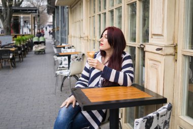 Uzun saçlı genç bayan dondurma yiyor.