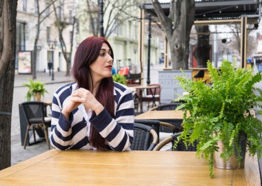 Uzun saçlı kafede yalnız oturan genç bayan