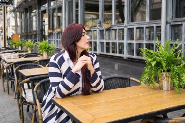Uzun saçlı kafede yalnız oturan genç bayan