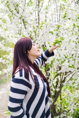 Çiçek açan ağaç dalları ile genç güzel kadın