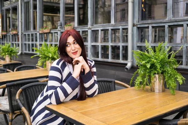 Uzun saçlı kafede yalnız oturan genç bayan