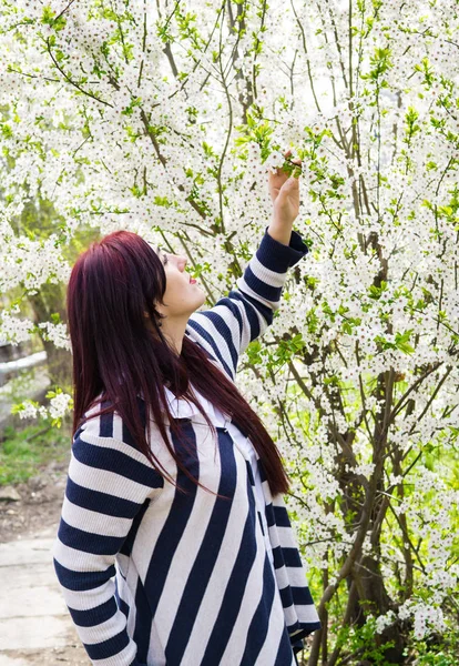 Çiçek açan ağaç dalları ile genç güzel kadın