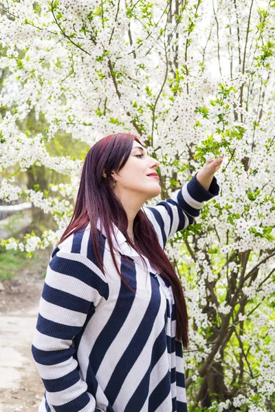 Jeune belle femme avec des branches d'arbre en fleurs — Photo