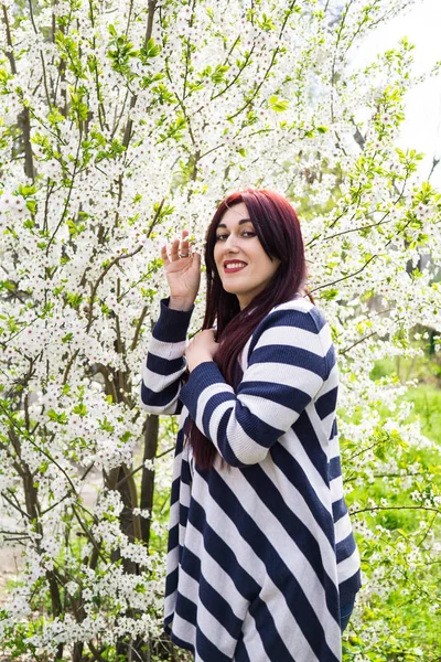 Çiçek açan ağaç dalları ile genç güzel kadın