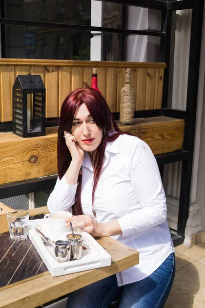 Joven mujer europea con cabello largo bebiendo café — Foto de Stock