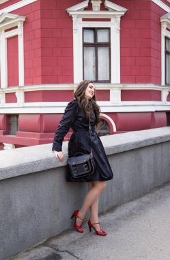 Şehirde poz veren siyah ceketli güzel gülümseyen genç bayan