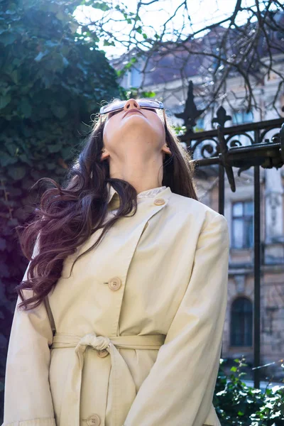 Schöne lächelnde junge Dame im beigen Mantel mit langen Haaren — Stockfoto