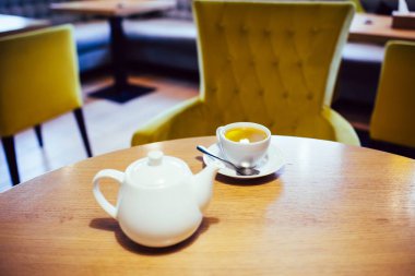 Bir fincan bitki çayı ve beyaz seramik çaydanlık