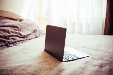 Ev yatak odası iç yatak battaniye üzerinde boş ekran ile yeni dizüstü bilgisayar