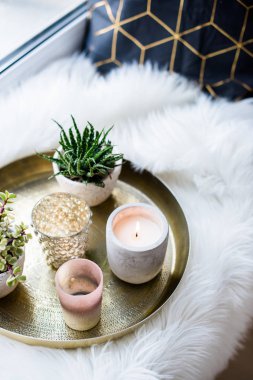 Rahat gerçek ev dekorasyonu, pencere üzerinde beyaz sahte kürk yastık ile altın tepside mumlar yanan