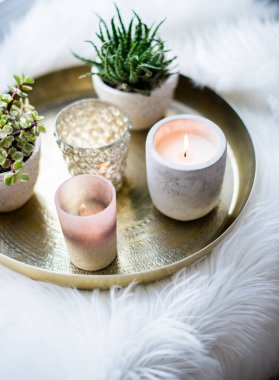 Rahat gerçek ev dekorasyonu, pencere üzerinde beyaz sahte kürk yastık ile altın tepside mumlar yanan