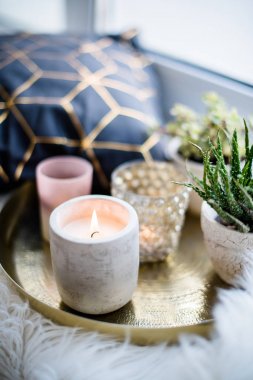 Rahat gerçek ev dekorasyonu, pencere üzerinde beyaz sahte kürk yastık ile altın tepside mumlar yanan